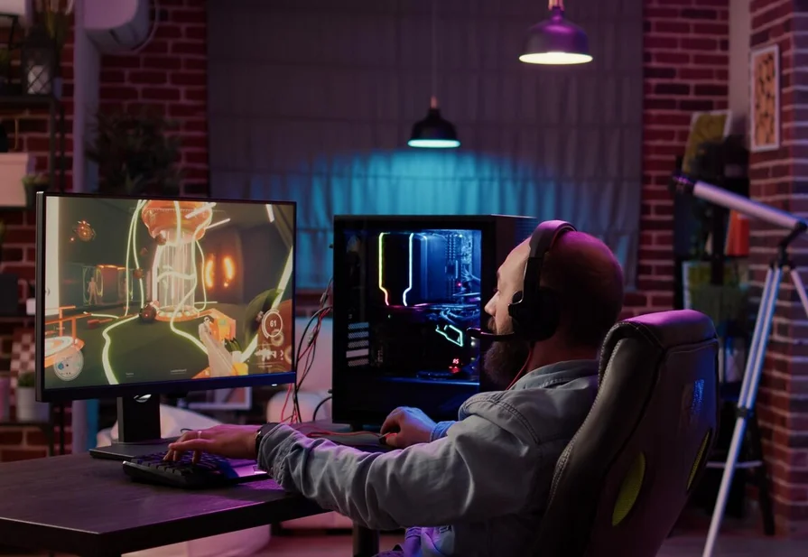 Joueur casqué devant un PC gamer dans un salon