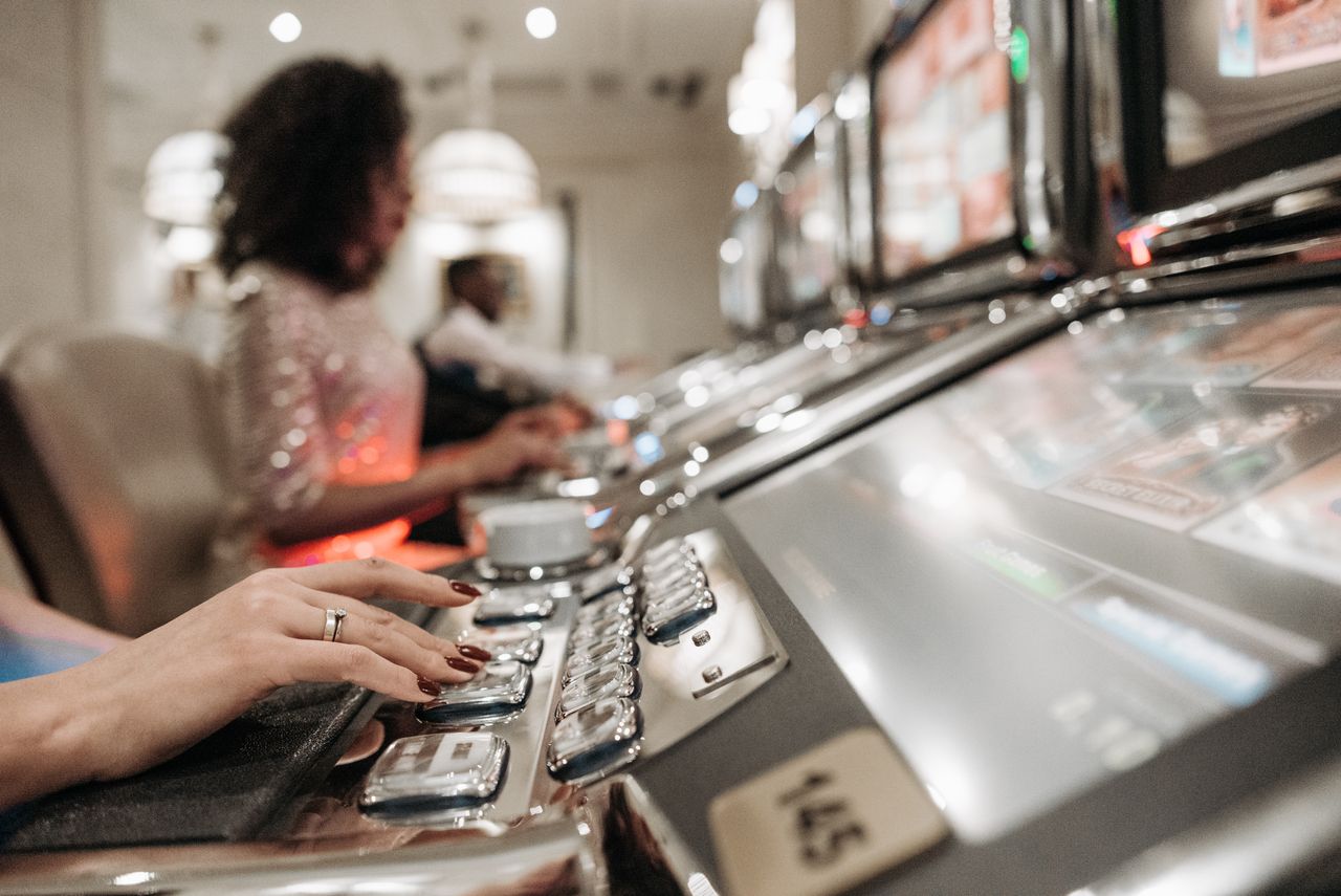 Personne jouant à une machine de jeu dans une salle éclairée