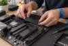 Un technicien portant un bracelet antistatique installe un SSD M.2 générique dans un ordinateur.