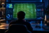 Analyste observant un terrain de football et des graphiques de données sur un écran.