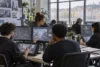 Des étudiants travaillent en équipe sur des projets de jeu vidéo dans un studio-école moderne.